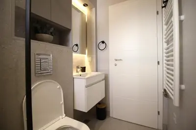 a small bathroom with a toilet and a sink at La Paloma Blanca in Tuzla