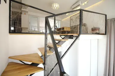 a spiral staircase in a room with a mirror at La Paloma Blanca in Tuzla