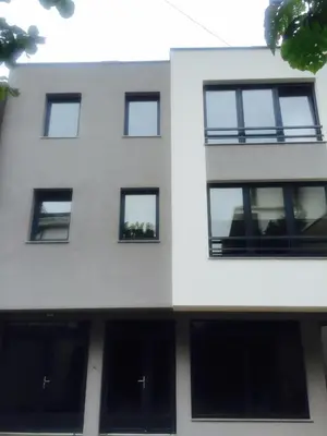 a white building with black windows at Apartment Adi in Travnik