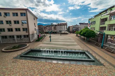 a fountain in the middle of a city with buildings at Apartments & Rooms Fountain in Bihać