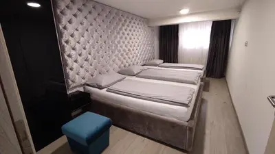 a bedroom with two beds and a blue stool at Apartmani Abbazia in Banja Luka