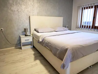 a bedroom with a large bed with white sheets and pillows at Apartmani Abbazia in Banja Luka