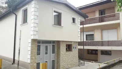 a white building with a door in front of it at Apartmani Abbazia in Banja Luka