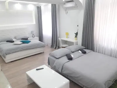 a bedroom with two beds and a table and a desk at Apartmani Abbazia in Banja Luka