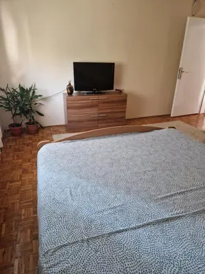a living room with a television and a blue rug at Guesthouse Irac in Tuzla