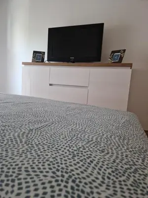 a bedroom with a bed and a television on a dresser at Guesthouse Irac in Tuzla