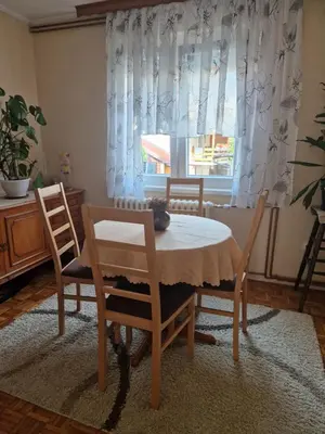 a dining room with a table and chairs and a window at Guesthouse Irac in Tuzla
