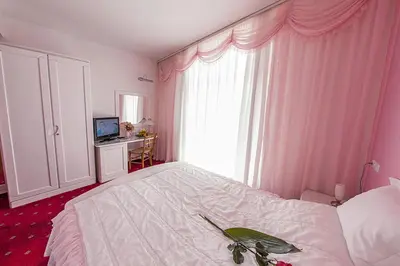 a bedroom with a white bed with a green plate on it at Hotel Senad od Bosne in Prokosovići