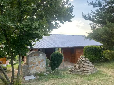 a stone structure in front of a cabin at Piramida Mjeseca in Visoko
