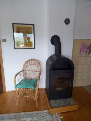 a room with a wood stove and a chair at Holiday Home Nana in Bugojno