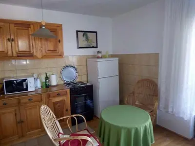 a kitchen with a table and a white refrigerator at Holiday Home Nana in Bugojno