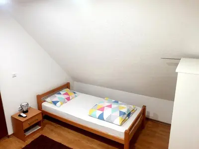 a small bedroom with a bed and a night stand at Natural Cottage Una in Bihać