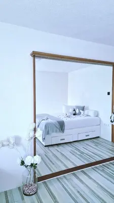a bedroom with a bed with a large mirror at Apartment Sekulic in Doboj