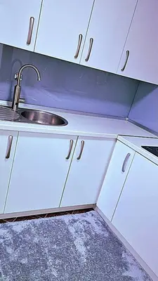 a kitchen with white cabinets and a sink at Apartment Sekulic in Doboj