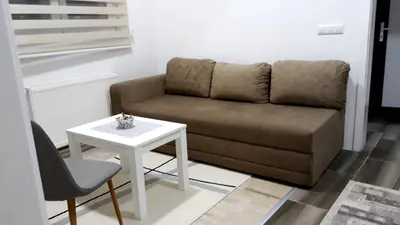 a living room with a couch and a table at AMAI Exclusive in Tuzla