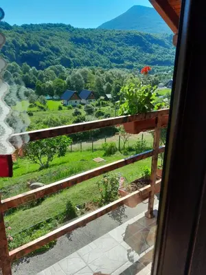 a view from a window of a field and mountains at Kuća za odmor Panorama Lohovo Bihać in Bihać