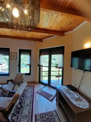 a living room with a couch and a flat screen tv at Kuća za odmor Panorama Lohovo Bihać in Bihać