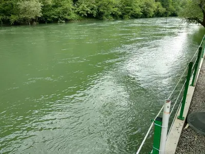 a boat is docked on the side of a river at Camp Vrbas in Rekavice
