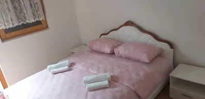 a bedroom with a pink bed with four pillows at Holiday Home Adna in Bihać