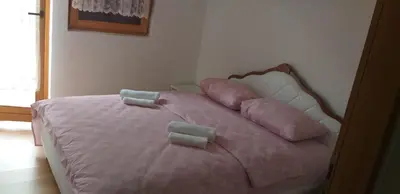 a pink bed with pink pillows on top of it at Holiday Home Adna in Bihać