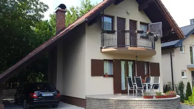 a house with a balcony and two chairs on a patio at Holiday Home Adna in Bihać