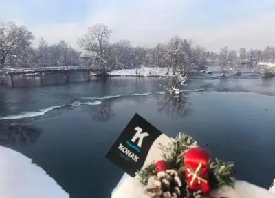 a frozen river with a sign in the snow at Konak na Uni in Bihać