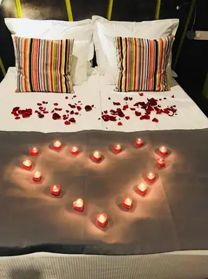 a bed with candles and rose petals on it at Konak na Uni in Bihać