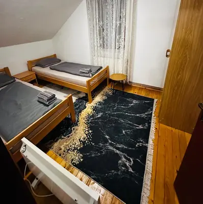 a room with two beds and a large rug at Rooms Cobras II in Jajce