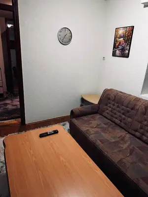 a living room with a couch and a clock on the wall at Rooms Cobras II in Jajce