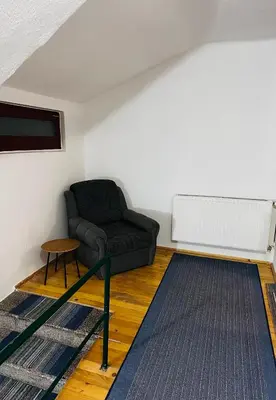 a living room with a black couch and a radiator at Rooms Cobras II in Jajce