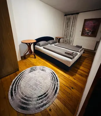 a bedroom with a bed and a wooden floor at Rooms Cobras II in Jajce