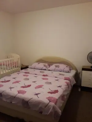 a bedroom with a bed with a pink comforter at Apartments Lela in Bihać