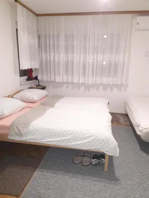 a bedroom with two beds and a window at Apartments Lela in Bihać