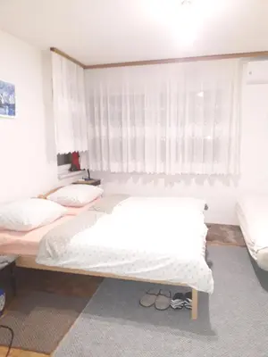a bedroom with two beds and a window at Apartments Lela in Bihać