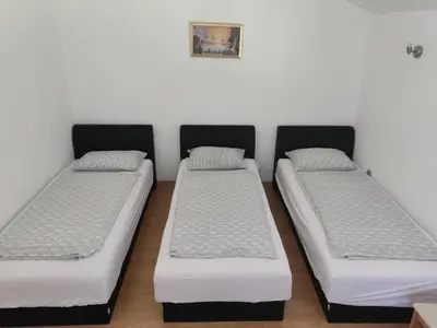 three beds are lined up in a room at Kuca Delić in Račić