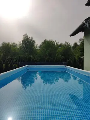 a blue swimming pool with trees in the background at Kuca Delić in Račić