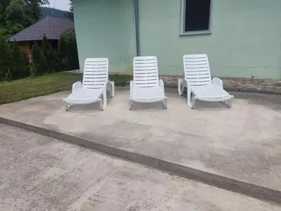 three white chairs sitting in front of a building at Kuca Delić in Račić