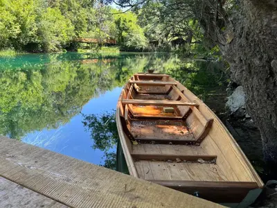 a wooden boat sitting on the side of a river at Kuca Delić in Račić