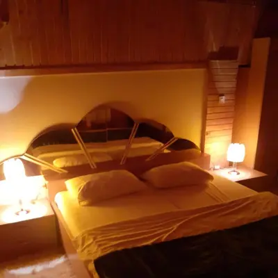 a bed in a room with two lamps and twoitures at Holiday Home Dzejla in Vlasic