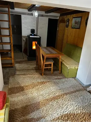 a living room with a table and a wood stove at Holiday Home Dzejla in Vlasic