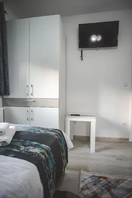 a bedroom with a bed and a tv on the wall at Villa La Unica in Lohovo