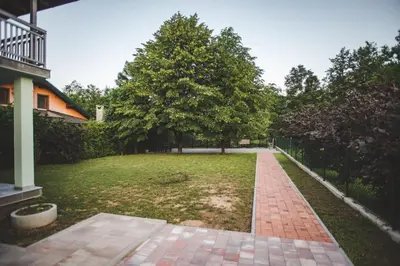 a garden with a brick walkway and trees at Villa La Unica in Lohovo