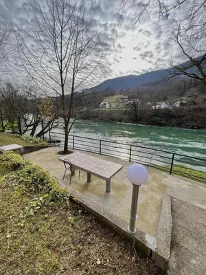 a picnic table with a view of a river at Holiday Homer Vila na Obali Vrbasa in Banja Luka