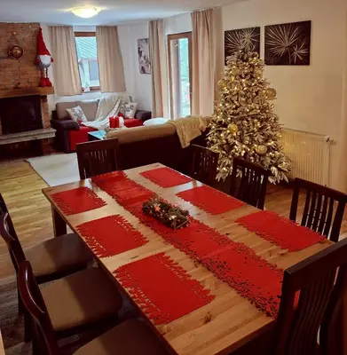 a living room with a table and a christmas tree at Apartments K.I.D.S. in Vlasic
