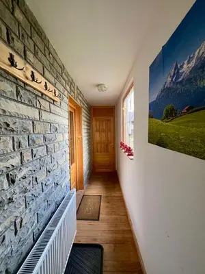 a hallway with a stone wall with a picture on the wall at Apartments K.I.D.S. in Vlasic