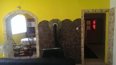 a living room with a stone fireplace and a couch at Apartman Ela in Bihać