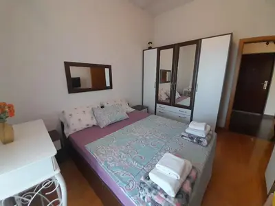 a small bedroom with a bed and a mirror at Apartment Nesrine in Bihać