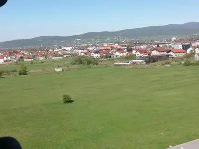 a green field with a town in the background at Apartment Nesrine in Bihać