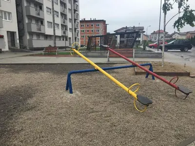 an empty playground with a yellow and blue swing at Apartment Nesrine in Bihać