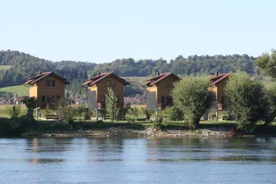 a row of houses on the banks of a river at Holiday homes Piralo in Kostajnica